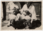 A Jewish woman in Lvov poses with a litter of puppies she is breeding.