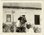 Close-up portrait of two Jewish children outside in the yard outside a building in Kniaze.