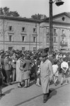 Jews gathered on the plaza at Zamenhofa and Nowolipki Streets in the Warsaw ghetto listen to an announcement on the public address system.