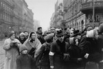 Jews are gathered at the intersection of Karmelicka and Nowolipki Streets in the Warsaw ghetto.