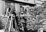 Polish and Jewish laborers construct a section of the wall that separated the Warsaw ghetto from the rest of the city.