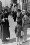 Jews converse on a street in the Warsaw ghetto.