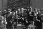 Jews are gathered on a street in the Warsaw ghetto.