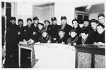Members of the Jewish police pose with administrators in an office in the Lodz ghetto.