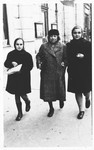 Two Jewish sisters walk along a street in Osijek, Croatia with their grandmother, who is wearing a Jewish badge.