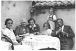 Members of the Spitzer family sit outside around a table.