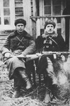 Two commissars of the Molotov partisan brigade pose outside with their rifles.