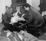 UN relief worker Greta Fischer helps Sophia and Janusz Karpaks pack for a trip to Switzerland, where they will spend several winter months with other  DP children from Prien, under the care of Swiss charitable organizations.