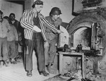 A Polish survivor shows U.S. soldier John L. Lyndon the crematorium ovens used to burn corpses in Dora-Mittelbau.
