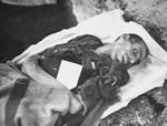 The body of a prisoner who died of starvation.  The tag on his body notes the cause of his death.