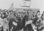 On the occasion of the first anniversary of the liberation of the Dautmergen concentration camp, Jewish survivors wearing concentration camp uniforms and carrying Zionist flags, bring wreaths to lay at the site.