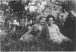 Two Jewish teenage friends sit outside in the grass.
