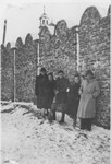 Manek D. Springut-Werdiger (center) stands with a group of friends against a section the Krakow ghetto wall.