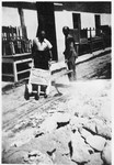 Two Jewish prisoners transport heavy rocks in a wheelbarrow in a Slovak labor camp.