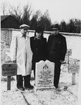 Three displaced persons pay their respects next to a grave in the Jewish cemetery in Neustadt.