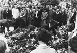 Jewish displaced persons place large bouquests of flowers on the ground during a memorial service for victims of the Nazis in Neustadt.
