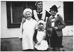 Four Jewish children pose together in their Purim costumes.