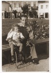 Usher Rosenzweig helping his son Izhak on a tricycle.