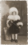 Studio portrait of a Jewish child from Warsaw dressed up in a fur hat and collar.