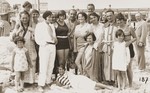 Inge Marx and Trude Zenner (extreme right) pose with their families on a beach on the Arendsee.