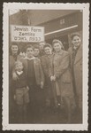 Members of the newly established hachshara [Zionist agricultural collective], Kibbutz Zettlitz, pose in front of the sign at the entrance to the farm.