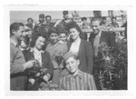 Members of the Buchenwald children's transport, one of whom is wearing a camp uniform, pose in the garden of the Ecouis children's home.