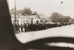 Jewish deportees under German guard march through the streets of Kamenets-Podolsk to an execution site outside of the city.