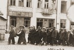 Jewish deportees march through the streets of Kamenets-Podolsk to an execution site outside of the city.
