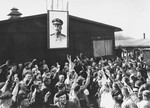 Survivors in Buchenwald cheer in front of a portrait of Stalin upon the liberation of the camp.