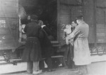 Members of the Ordedienst (Jewish police) give assistance to prisoners boarding a deportation train in the Westerbork transit camp.
