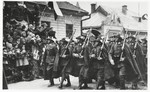 Ceremonial Polish troops march down a street in Sanok, past a reviewing stand that included the Rabbi of Sanok, Tuvia Horowitz.
