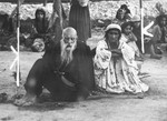 A Romani couple sits in an open area in the Belzec concentration camp.