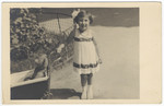 Ruth Landau, a young Austrian Jewish girl, pushes her teddy bear in a stroller.