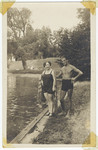 An Jewish couple wearing bathing suits poses next to a lake.
