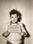 Josef Nowak holds a name card intended to help any of his surviving family members locate him at the Kloster Indersdorf DP camp.