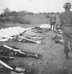 An American soldier and medic walk among corpses found in the Ohrdruf concentration camp.