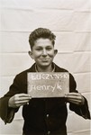 Henryk Luczynski holds a name card intended to help any of his surviving family members locate him at the Kloster Indersdorf DP camp.