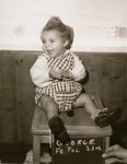 Polish toddler George, surname unknown, with a name card intended to help any of his surviving family members locate him at the Kloster Indersdorf DP camp.