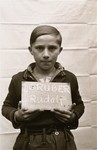 Rudolf Gruber holds a name card intended to help any of his surviving family members locate him at the Kloster Indersdorf DP camp.