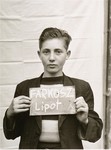 Lipot Farkosz holds a name card intended to help any of his surviving family members locate him at the Kloster Indersdorf DP camp.