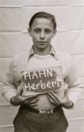 Herbert Hahn holds a name card intended to help any of his surviving family members locate him at the Kloster Indersdorf DP camp.