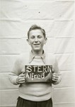 Alfred Stern holds a name card intended to help any of his surviving family members locate him at the Kloster Indersdorf DP camp.