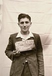 Otto Schwartz holds a name card intended to help any of his surviving family members locate him at the Kloster Indersdorf DP camp.
