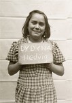 Hedvig Dydyna holds a name card intended to help any of her surviving family members locate her at the Kloster Indersdorf DP camp.