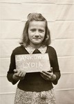 Lydia Jankowski holds a name card intended to help any of her surviving family members locate her at the Kloster Indersdorf DP camp.