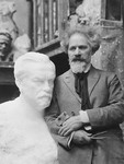 Sculptor Naum Aronson poses next to his sculpture of Louis Pasteur.