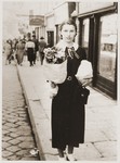 Fritzi Brender carrying flowers for her teacher on a street in Cernauti.
