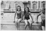 Mia Kaufman (right) poses sitting on a wall with a friend.