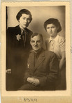 Studio portrait of a family in the Lodz ghetto wearing yellow stars.