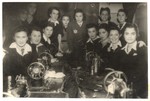 Group portrait of teenage girls and teachers wearing Stars of David in a sewing workshop in the Lodz ghetto.